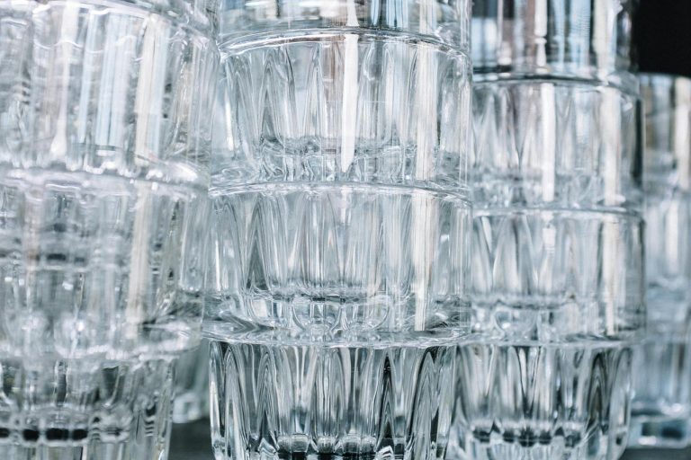 Close-up of stacked clear glasses with a focus on their intricate patterns and reflections.