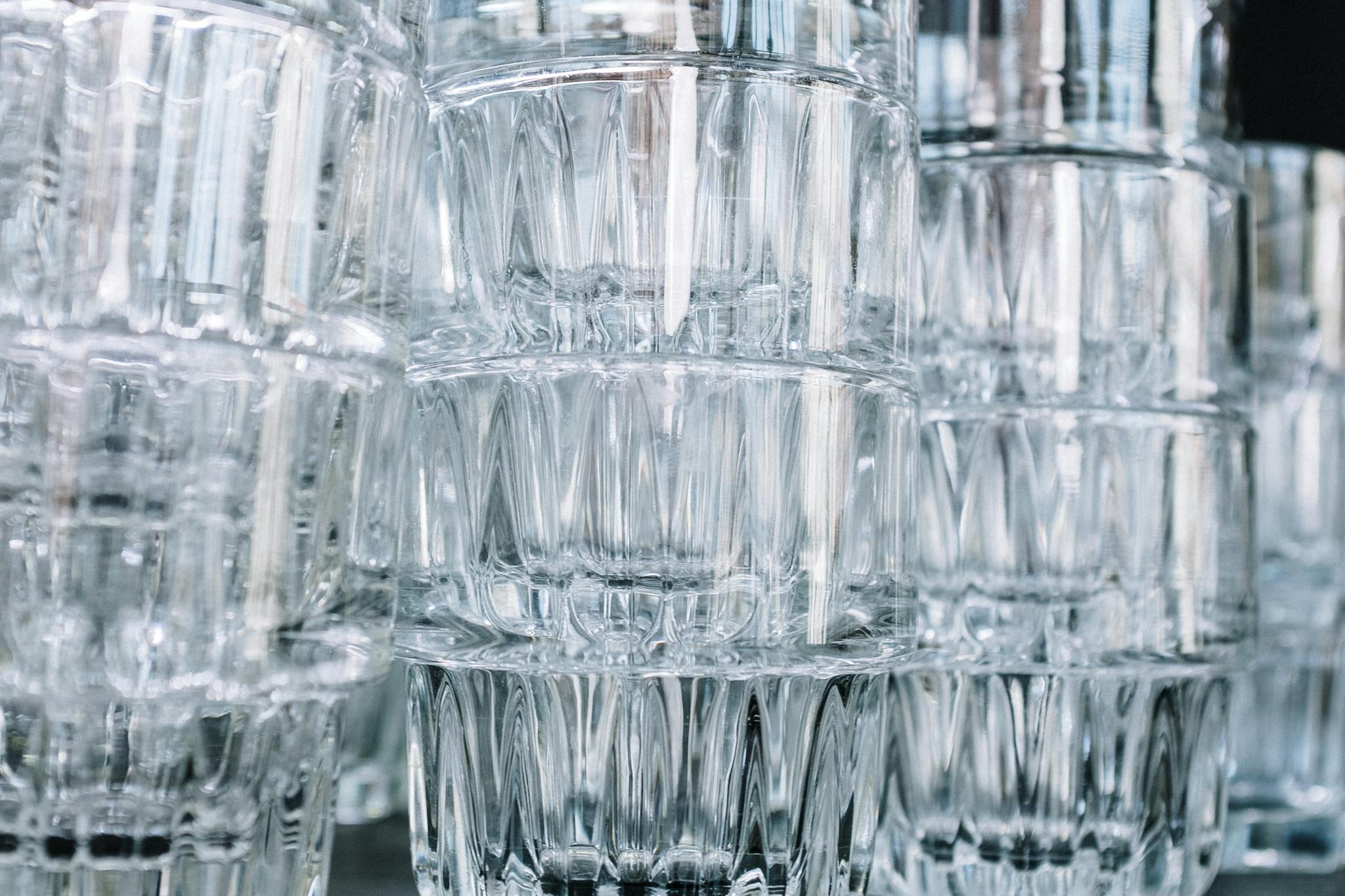 Close-up of stacked clear glasses with a focus on their intricate patterns and reflections.